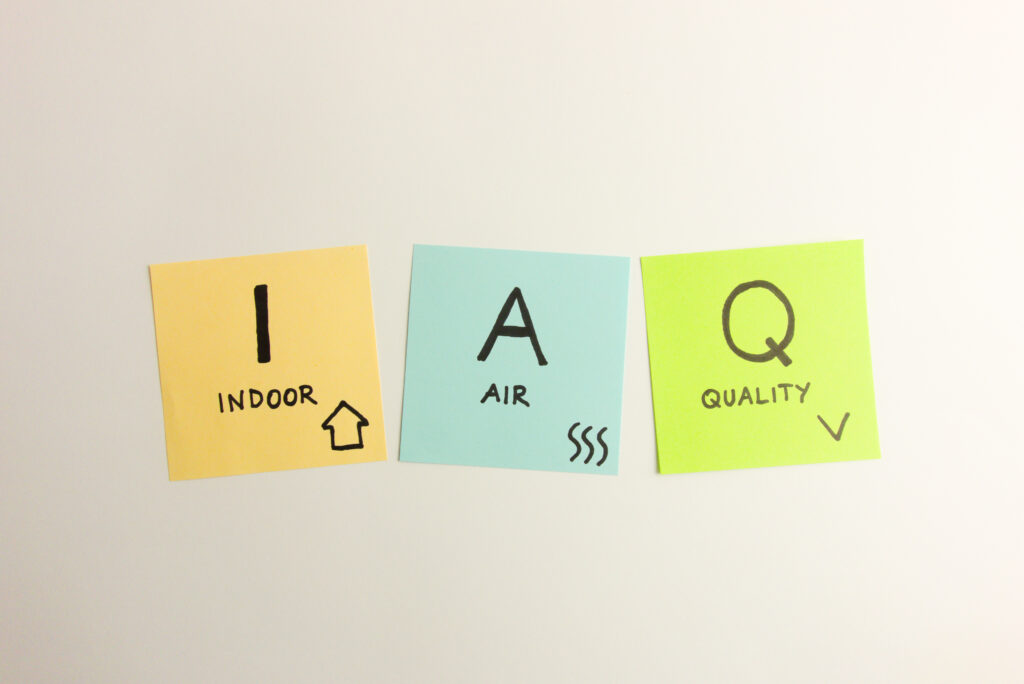 IAQ indoor air quality acronym handwritten on sticky notes on white background